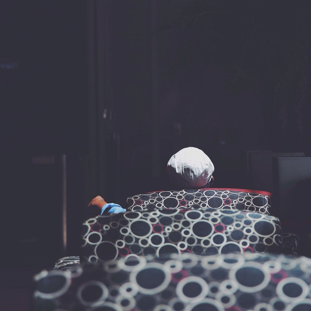 Person sitting alone lost in thought, illustrating the feeling of loneliness even around others