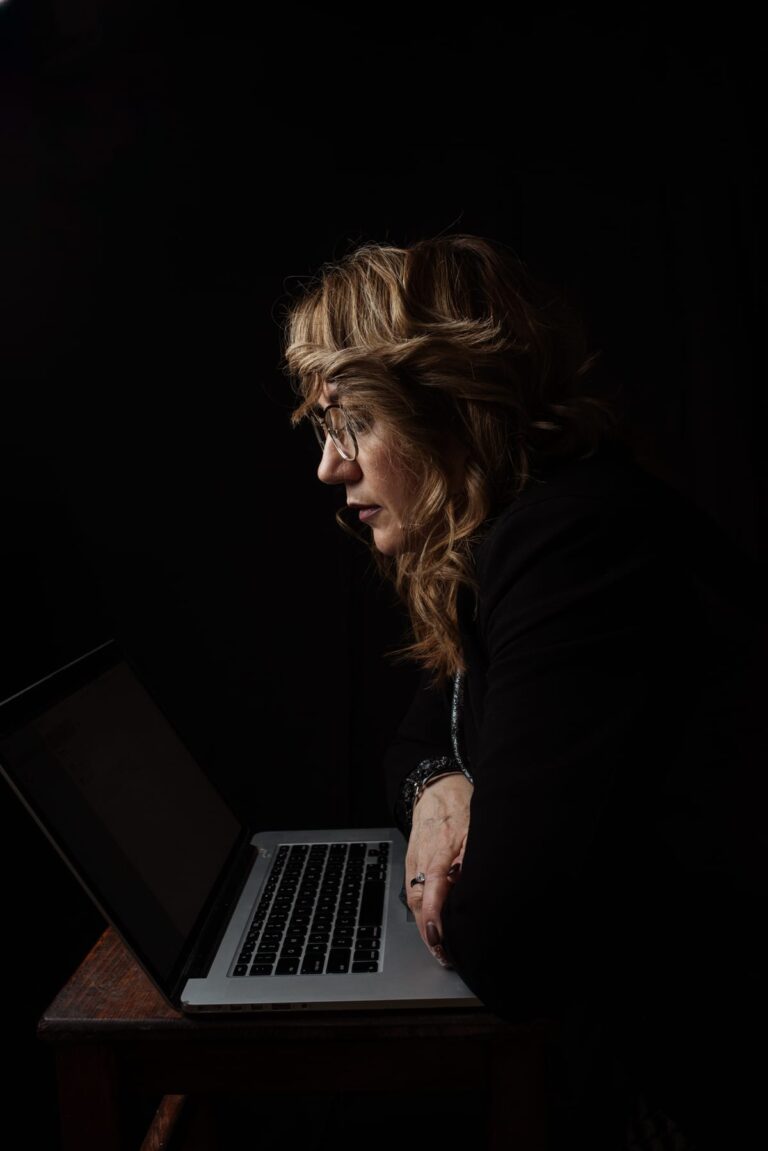 Woman deeply focused, working late on her laptop, pushing through to finish what she started